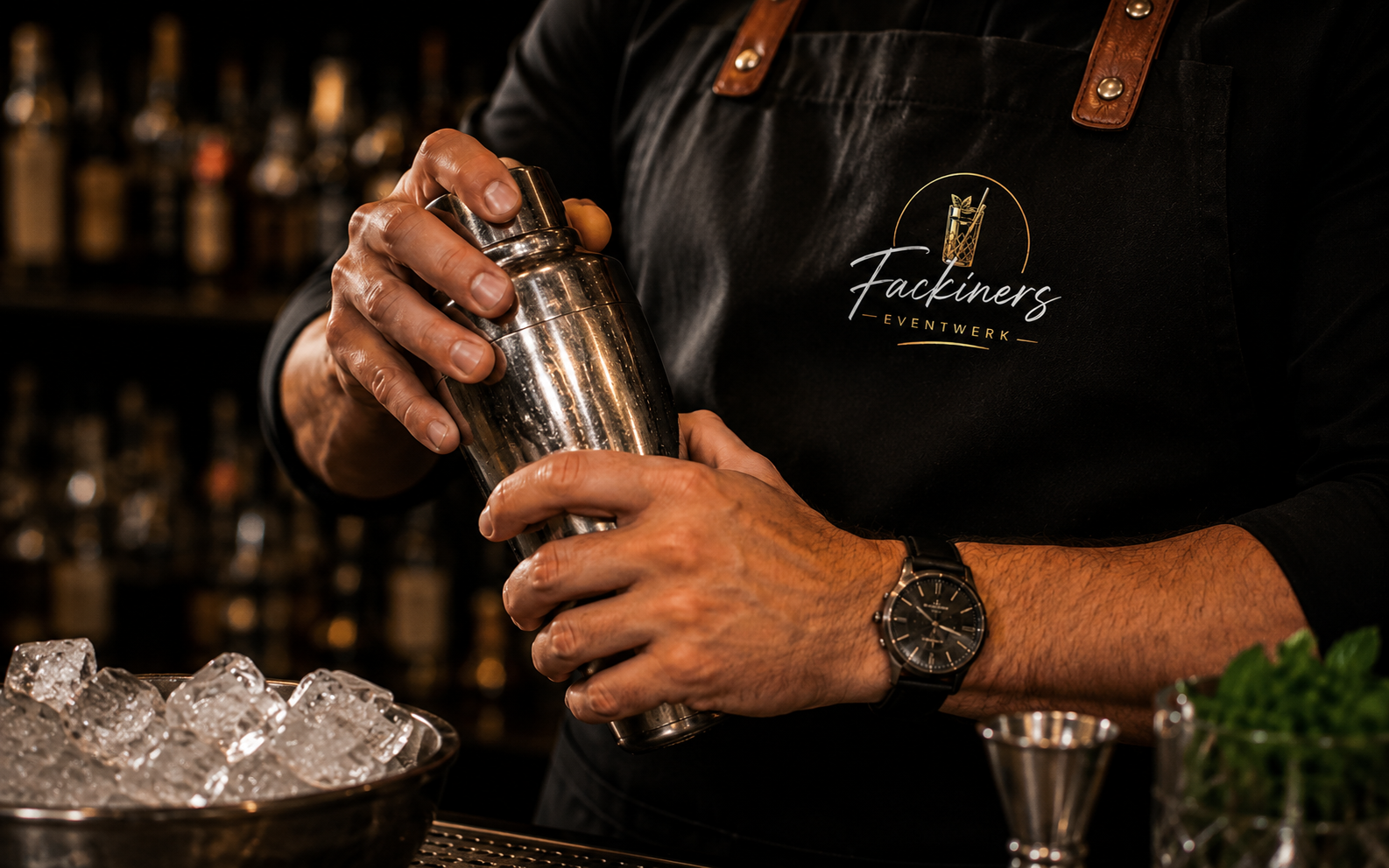 Barkeeper bereitet mit Shaker und Eis Cocktails vor
